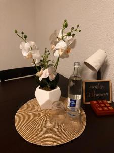 a table with a bottle of wine and a vase with flowers at Ferienwohnung EG in Gräfenhainichen