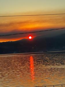 a sunset over the water with a reflection in the water at Apartament Lyonnet in Orşova