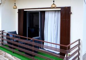 a balcony with a sliding glass door with a chair at Revkon Apartments in Abuja