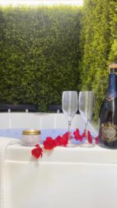 a table with two glasses and a bottle of wine at Dream Wellness Suite in Barletta