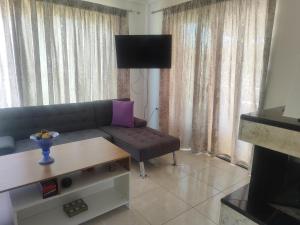 a living room with a couch and a table at Maisonette Kalypso in Diakopto