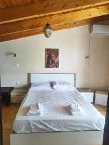 a bedroom with a white bed with a wooden ceiling at Maisonette Kalypso in Diakopto