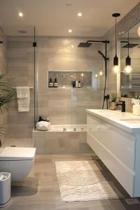 a bathroom with a shower and a toilet and a sink at ErviApartments in Tirana