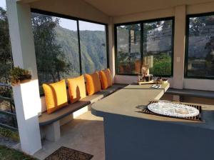a living room with yellow pillows on a bench at La Enamorada Cabañas & Resort in Zacatlán +15 photos