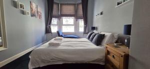 a bedroom with a bed and a desk and a window at Bishop Street Apartment in Rothesay
