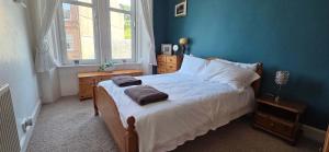 a bedroom with a bed with two towels on it at Bishop Street Apartment in Rothesay