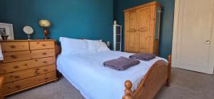 a bedroom with a bed with two towels on it at Bishop Street Apartment in Rothesay
