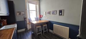 a kitchen with a counter and a table and a window at Bishop Street Apartment in Rothesay