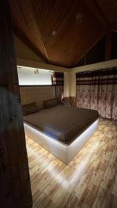 a large bed in a room with a wooden floor at Himalayan Whisper in Kulu