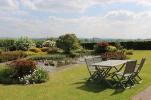 a picnic table and two chairs in a garden at Mortimer Trail B and B in Aymestrey