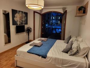 a bedroom with a bed with a blue blanket at STUDIO TAGORO in Costa Del Silencio