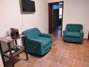 two green chairs and a table in a room at Casa del Sole 2 artenatura in Pergola