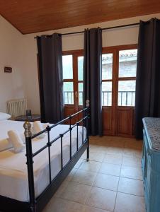 a bedroom with a bed and two windows at Albergue de Ruesta in Ruesta