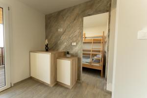 a room with a mirror and a bedroom with a bunk bed at Hiška pod vrhom in Poljane nad Škofjo Loko