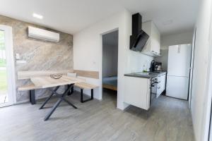 a small kitchen with a table and a refrigerator at Hiška pod vrhom in Poljane nad Škofjo Loko