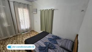 a small bedroom with a bed and a window at Casa Vigia 2 Quartos in Vigia