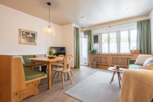 a living room with a table and a couch at Kreuzwegerhof Nals - Historic Nature Stay with Pool near Meran & Bozen in Nalles