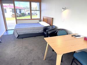 a room with a bed and a table and chairs at Charlton Motel in Gore