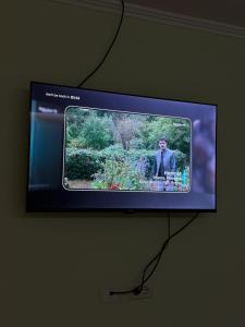 a television screen with a picture of a man on it at Prestige ESP ROOMS in Poliçan