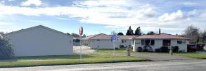 a house on a street with a white garage at Charlton Motel in Gore