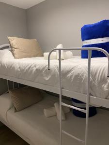 a bunk bed with white sheets and pillows on it at Casa Malbec en Los Molles in Las Lenas