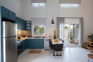 a kitchen with blue cabinets and a table with chairs at Dante Home's in Corfu