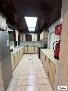 a kitchen with wooden cabinets and a ceiling at marjan beach in Dhahran