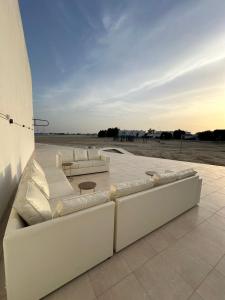 a group of white couches sitting on a patio at marjan beach in Dhahran