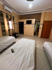 a hotel room with two beds with white sheets at Merzouga Roms in Merzouga