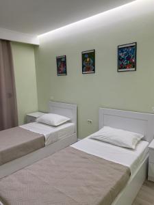two beds sitting next to each other in a bedroom at Prestige ESP ROOMS in Poliçan