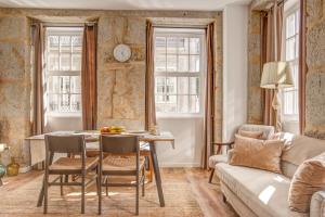 a living room with a table and chairs and a couch at Elegant City House Moderno no Centro da Cidade in Chaves