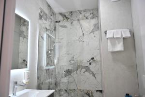 a bathroom with a shower and a sink and a mirror at Juna's Hotel in Prizren +11 photos