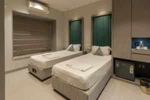 a hotel room with two beds and a flat screen tv at The Bay Suites - MMR in New Town