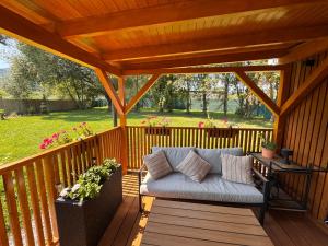 a porch with a couch on a wooden deck at Domček pod Vežami s vírivkou a grilom, pri termálnom kúpalisku in Liptovský Ján