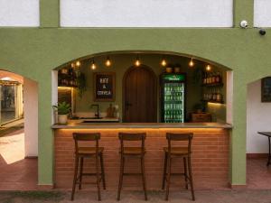 a bar with three stools in front of a building at Motel carioca in Miguel Pereira