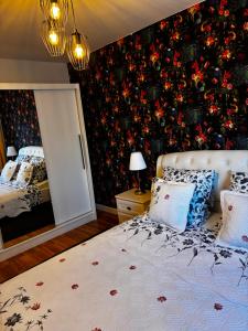a bedroom with a bed with a floral wall at Apartament Lyonnet in Orşova