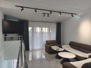 a living room with a couch and a flat screen tv at Apartmani Orlović Bar in Bar