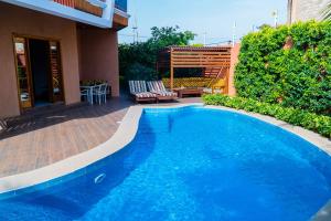a large blue swimming pool next to a building at Pericare Évasion Saly Espace exclusivement féminin in Saly Portudal