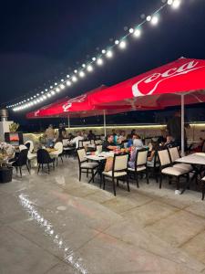 a group of people sitting at tables under a cocacola umbrella at Fortuna Hotel in Batumi +12 photos