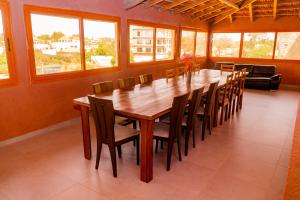 a large dining room with a large wooden table and chairs at Pericare Évasion Saly Espace exclusivement féminin in Saly Portudal