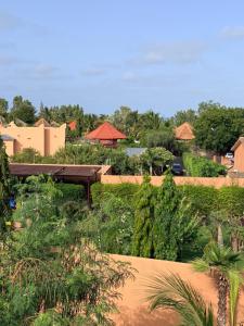 a park with a bench and trees and buildings at Pericare Évasion Saly Espace exclusivement féminin in Saly Portudal