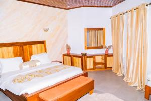 a bedroom with a large bed and a window at Pericare Évasion Saly Espace exclusivement féminin in Saly Portudal +24 photos