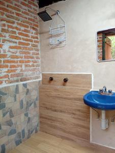 a bathroom with a blue sink and a brick wall at Cabañas Ticomulco in Zacatlán