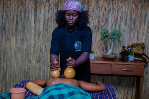 a young boy is holding up two pumpkins on his abdomen at Pericare Évasion Saly Espace exclusivement féminin in Saly Portudal