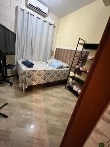 a small bedroom with a bed and a window at Casa em Marataízes - Espírito Santo in Marataizes