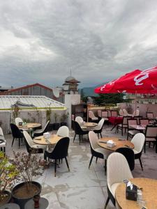 a patio with tables and chairs and an umbrella at Fortuna Hotel in Batumi