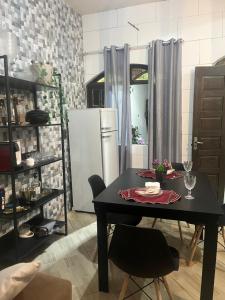 a dining room with a table and a refrigerator at Casa em Marataízes - Espírito Santo in Marataizes