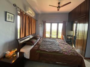 a bedroom with a large bed and a window at Dona Paula Apartment in Dona Paula