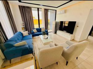 a living room with a blue couch and chairs at Dahab Luxury Villa with Private Pool in Al Rama