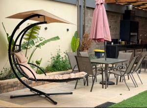 a patio with a table and chairs and an umbrella at Dahab Luxury Villa with Private Pool in Al Rama